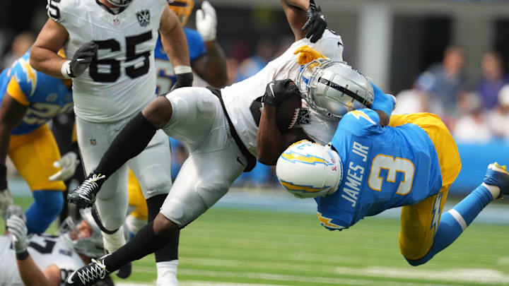 Sep 8, 2024; Inglewood, California, USA; Las Vegas Raiders running back Zamir White (left) is tackled by Los Angeles Chargers safety Derwin James Jr (3) in the second half at SoFi Stadium. Mandatory Credit: Kirby Lee-Imagn Images
