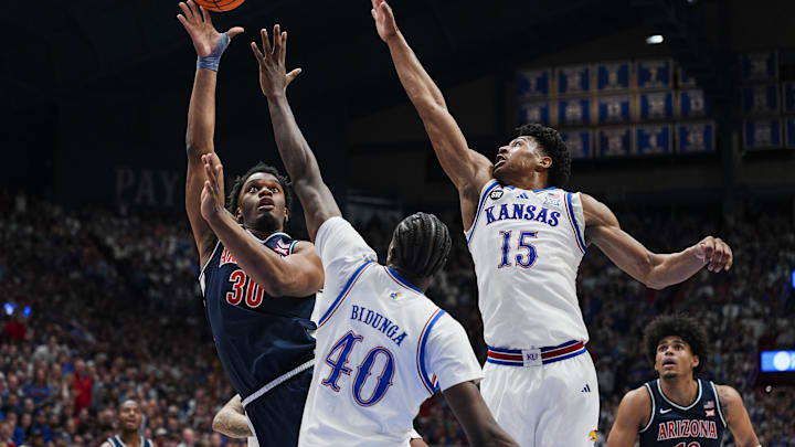 Feb 7, 2026; Lawrence, Kansas, USA; Arizona Wildcats forward Tobe Awaka (30) shoots against Kansas Jayhawks forward Flory Bidunga (40) and forward Bryson Tiller (15) during the first half at Allen Fieldhouse. Mandatory Credit: Jay Biggerstaff-Imagn Images