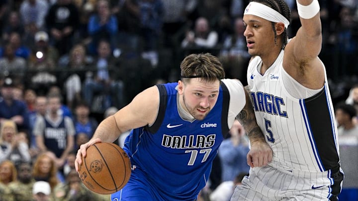 Jan 29, 2024; Dallas, Texas, USA; Dallas Mavericks guard Luka Doncic (77) drives to the basket past Orlando Magic forward Paolo Banchero (5) during the second half at the American Airlines Center. Mandatory Credit: Jerome Miron-Imagn Images