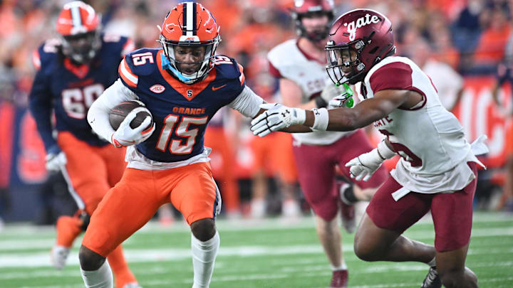 Sep 12, 2025; Syracuse, New York, USA; Syracuse Orange wide receiver Darrell Gill Jr. (15) tries to avoid a tackle by Colgate Raiders defensive back Tymir Wynn (6) in the first quarter at the JMA Wireless Dome. Mandatory Credit: Mark Konezny-Imagn Images