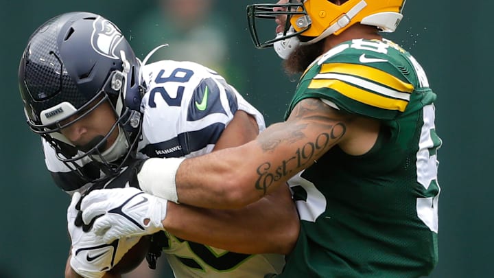 Green Bay Packers linebacker Isaiah McDuffie (58) tackles Seattle Seahawks running back Zach Charbonnet (26) during their preseason football game Saturday, August 26, 2023, at Lambeau Field in Green Bay, Wis. Green Bay defeated Seattle 19-15.