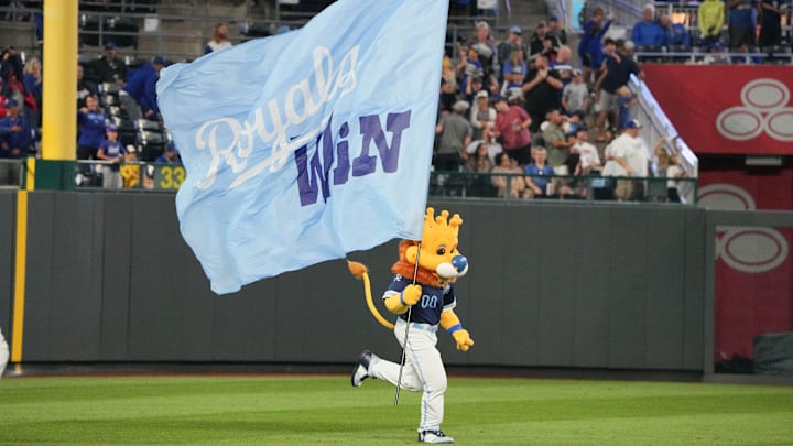Sep 6, 2024; Kansas City, Missouri, USA; The Kansas City Royals mascot Sluggerrr runs on field with a large flag after the win over the Minnesota Twins at Kauffman Stadium. Mandatory Credit: Denny Medley-Imagn Images Sep 6, 2024; Kansas City, Missouri, USA; The Kansas City Royals mascot Sluggerrr runs on field with a large flag after the win over the Minnesota Twins at Kauffman Stadium. Mandatory Credit: Denny Medley-Imagn Images