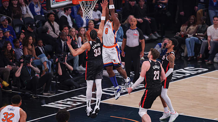Mar 30, 2025; New York, New York, USA; New York Knicks forward OG Anunoby (8) goes up for a dunk during the first half in front of Portland Trail Blazers center Donovan Clingan (23) and forward Toumani Camara (33) at Madison Square Garden. Mandatory Credit: Vincent Carchietta-Imagn Images