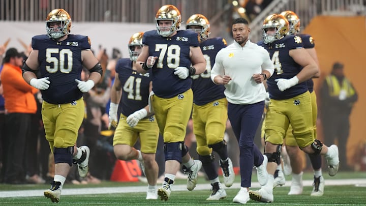 Jan 20, 2025; Atlanta, GA, USA; Notre Dame Fighting Irish head coach Marcus Freeman and his players run to the field before playing against the Ohio State Buckeyes in the CFP National Championship college football game at Mercedes-Benz Stadium. Mandatory Credit: Kirby Lee-Imagn Images