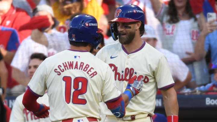 Oct 5, 2024; Philadelphia, PA, USA;  Philadelphia Phillies designated hitter Kyle Schwarber (12) celebrates with Philadelphia Phillies first baseman Bryce Harper (3) after a solo home run against the New York Mets in the first inning in game one of the NLDS for the 2024 MLB Playoffs at Citizens Bank Park. 