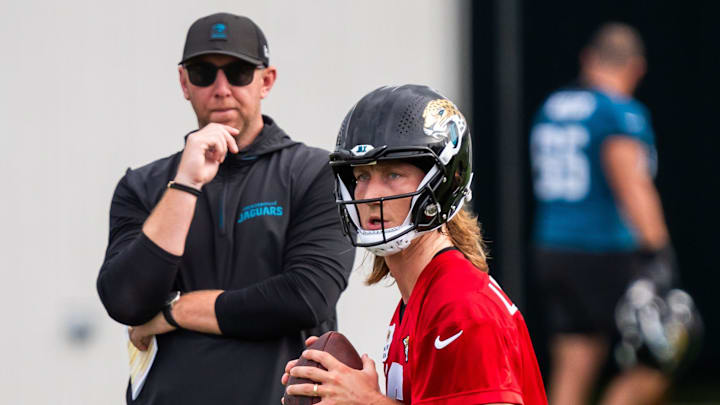 Jacksonville Jaguars quarterback Trevor Lawrence (16) falls back as Jacksonville Jaguars head coach Liam Coen watches during the Jacksonville Jaguars’ mandatory minicamp Tuesday June 10, 2025 at the Miller Electric Center in Jacksonville, Fla. [Doug Engle/Florida Times-Union]