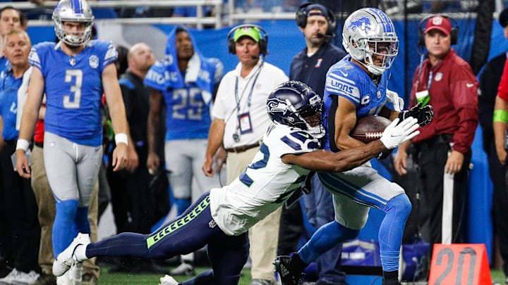 Detroit Lions wide receiver Amon-Ra St. Brown makes a catch and then fumbles against Seattle Seahawks cornerback Tre Brown on the final play of the first half at Ford Field in Detroit on Sunday, Sept. 17, 2023.