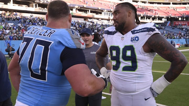 Nov 23, 2025; Nashville, Tennessee, USA; Tennessee Titans guard Kevin Zeitler (70) and Seattle Seahawks defensive end Leonard Williams (99) meet after a game at Nissan Stadium. Mandatory Credit: Steve Roberts-Imagn Images