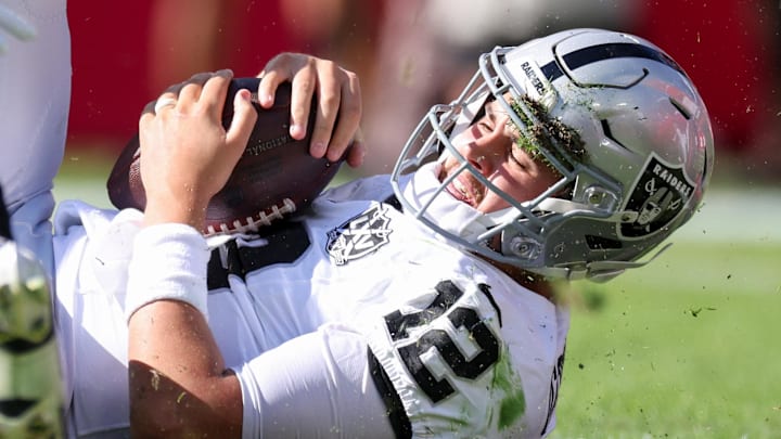 Dec 8, 2024; Tampa, Florida, USA; Las Vegas Raiders quarterback Aidan O'Connell (12) is sacked by Tampa Bay Buccaneers linebacker Lavonte David (54) in the first quarter at Raymond James Stadium. Mandatory Credit: Nathan Ray Seebeck-Imagn Images