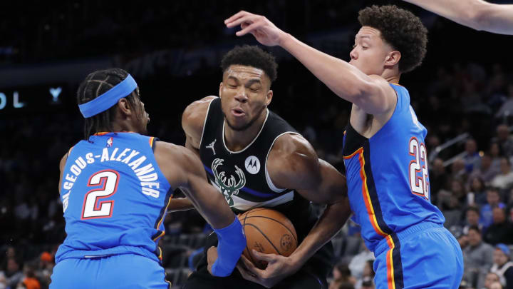 Mar 8, 2022; Oklahoma City, Oklahoma, USA; Milwaukee Bucks forward Giannis Antetokounmpo (34) moves to the basket against Oklahoma City Thunder guard Shai Gilgeous-Alexander (2) and forward Isaiah Roby (22) during the second half at Paycom Center. Milwaukee won 142-115. Mandatory Credit: Alonzo Adams-USA TODAY Sports