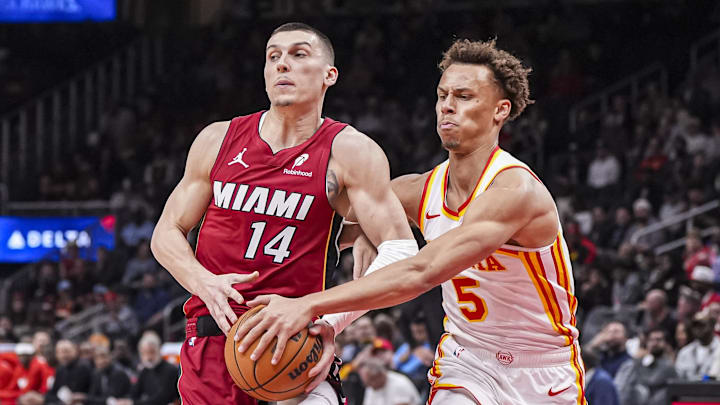 Feb 24, 2025; Atlanta, Georgia, USA; Miami Heat guard Tyler Herro (14) tries to protect the ball against Atlanta Hawks guard Dyson Daniels (5) during the first half at State Farm Arena. Mandatory Credit: Dale Zanine-Imagn Images