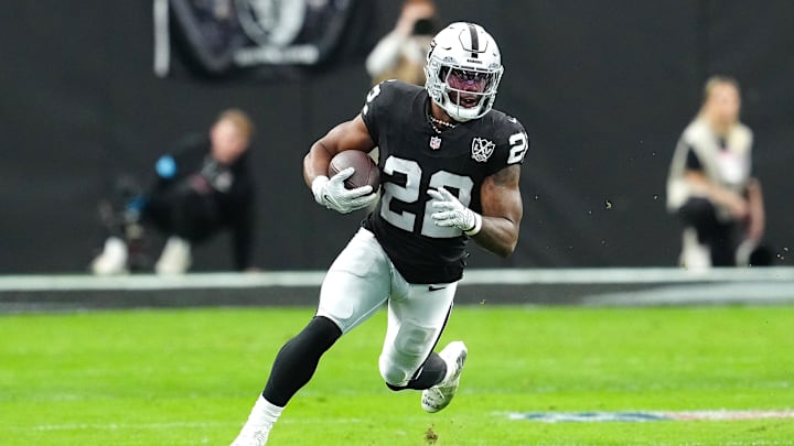 Jan 5, 2025; Paradise, Nevada, USA; Las Vegas Raiders running back Alexander Mattison (22) gains yardage against the Los Angeles Chargers during the first quarter at Allegiant Stadium. Mandatory Credit: Stephen R. Sylvanie-Imagn Images
