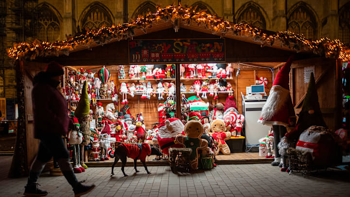 A man walks with his dog in front of the soft toy shop at...