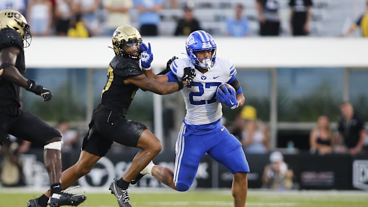 Oct 26, 2024; Orlando, Florida, USA;  Brigham Young Cougars running back LJ Martin (27) runs the ball against Central Florida Knights cornerback Chasen Johnson (27) in the second half at FBC Mortgage Stadium. Mandatory Credit: Russell Lansford-Imagn Images