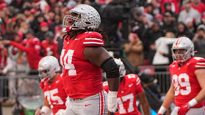 Ohio State Buckeyes offensive lineman Donovan Jackson (74) celebrates a touchdown by TreVeyon Henderson during the NCAA football game against the Indiana Hoosiers at Ohio Stadium in Columbus on Monday, Nov. 25, 2024. Ohio State won 38-15.