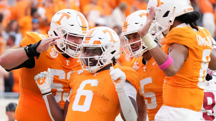 Tennessee offensive lineman Cooper Mays (63), wide receiver Bru McCoy (5), and quarterback Nico Iamaleava (8) surround running back Dylan Sampson (6) in celebration after Sampson's touchdown during an NCAA college football game against Alabama on Saturday, Oct. 19, 2024, in Knoxville. Tenn.