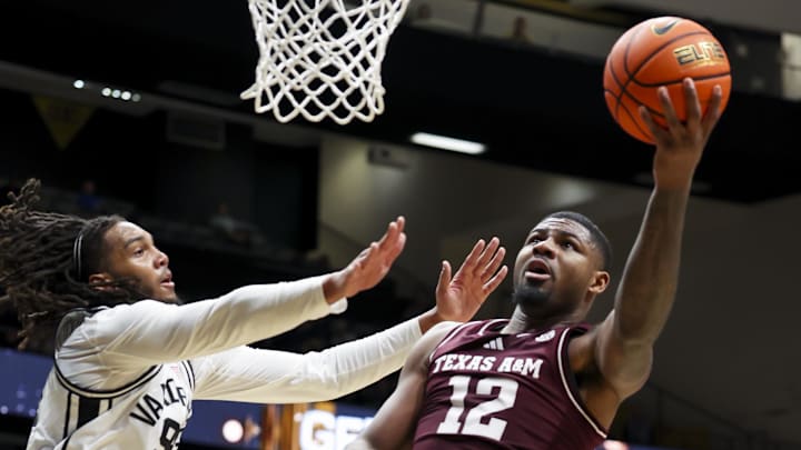 Feb 14, 2026; Nashville, Tennessee, USA; Texas A&M Aggies forward Rashaun Agee (12) lays the ball in over Vanderbilt Commodores forward Devin McGlockton (99) during the first half at Memorial Gymnasium. Mandatory Credit: Steve Roberts-Imagn Images