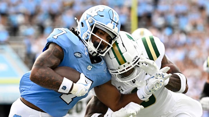 Sep 7, 2024; Chapel Hill, North Carolina, USA; North Carolina Tar Heels wide receiver Christian Hamilton (7) with the ball as Charlotte 49ers defensive back Al-Ma'hi Ali (0) defends in the second quarter at Kenan Memorial Stadium. Mandatory Credit: Bob Donnan-Imagn Images