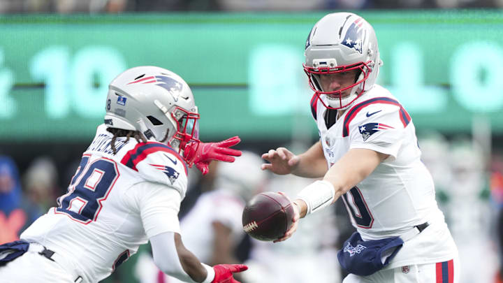 Dec 28, 2025; East Rutherford, New Jersey, USA; New England Patriots quarterback Drake Maye (10) hands the ball off to running back Rhamondre Stevenson (38) during the first quarter of the game against the New York Jets at MetLife Stadium. Mandatory Credit: Robert Deutsch-Imagn Images