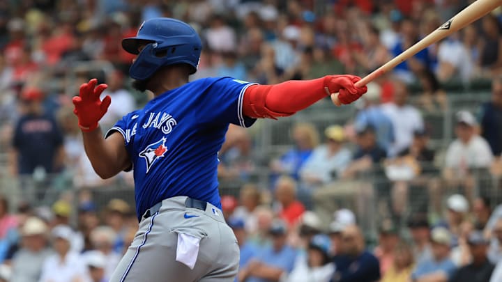 Feb 22, 2026; Fort Myers, Florida, USA; Toronto Blue Jays designated hitter Eloy Jimenez (74) hits an RBI double during the first inning against the Boston Red Sox  at JetBlue Park at Fenway South. Mandatory Credit: Kim Klement Neitzel-Imagn Images