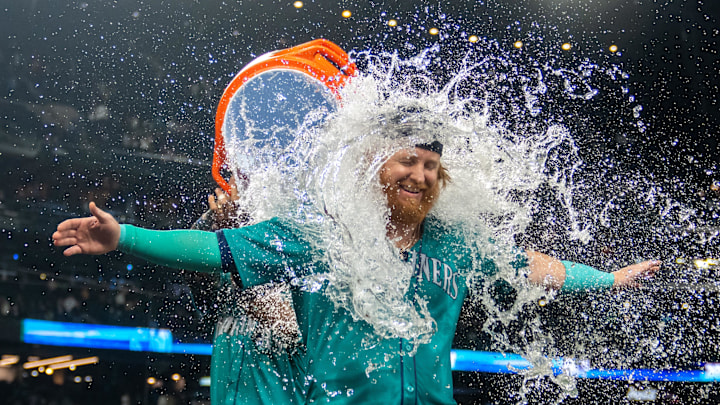 Sep 28, 2024; Seattle, Washington, USA; Seattle Mariners pinch hitter Justin Turner (2) is doused with water by centerfielder Julio Rodriguez (44) after a game against the Oakland Athletics at T-Mobile Park.