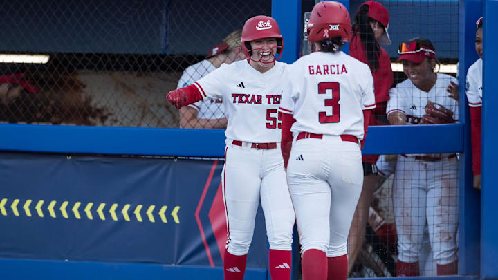 May 31, 2025; Oklahoma City, OK, USA; Texas Tech Red Raiders utility Bailey Lindemuth (55) smiles and congratulates Texas Tech Red Raiders infielder Hailey Toney (32) after she stole home and scored in the fifth inning against the UCLA Bruins during the NCAA Softball Women's College World Series at Devon Park. Mandatory Credit: Brett Rojo-Imagn Images