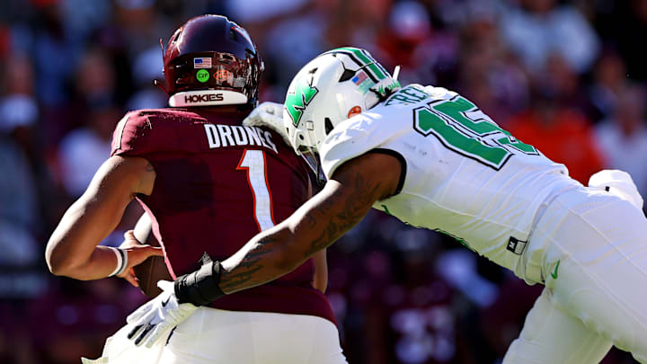 Sep 7, 2024; Blacksburg, Virginia, USA; Marshall Thundering Herd defensive lineman Mike Green (15) sacks Virginia Tech Hokies quarterback Kyron Drones (1) during the first quarter at Lane Stadium. Mandatory Credit: Peter Casey-Imagn Images