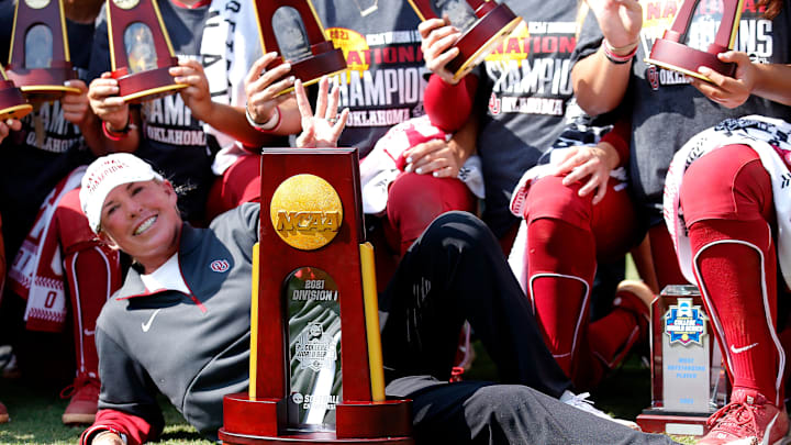 Oklahoma head coach Patty Gasso poses with the championship trophy following the final game of Women's College World Series championship series. 