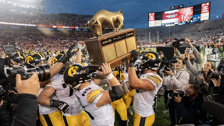 Oct 14, 2023; Madison, Wisconsin, USA; Iowa Hawkeyes players hoist The Heartland Trophy after defeating the Wisconsin Badgers at Camp Randall Stadium. Mandatory Credit: Mark Hoffman-Imagn Images