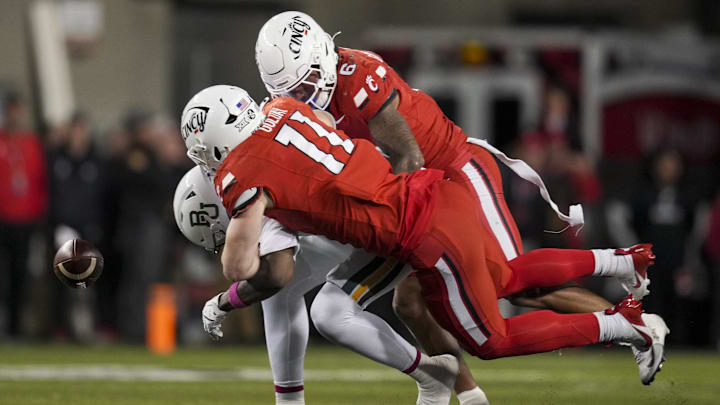 Oct 25, 2025; Cincinnati, Ohio, USA;  Baylor Bears tight end Michael Trigg (1) is unable to hold on to a catch as he is tackled by Cincinnati Bearcats linebacker Jake Golday (11) and defensive back Tre Gola-Callard (6) in the second half at Nippert Stadium. Mandatory Credit: Aaron Doster-Imagn Images