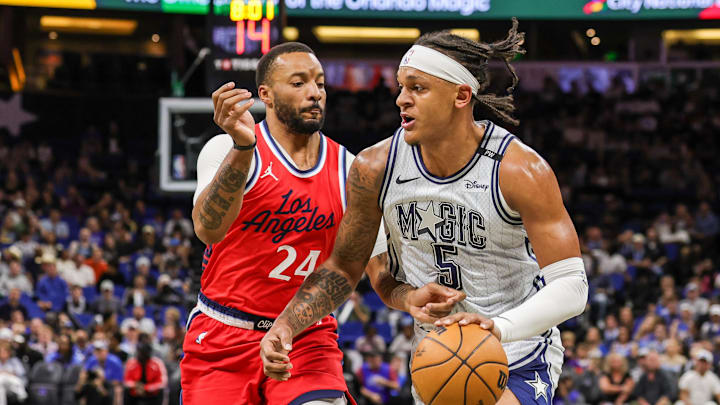 Mar 31, 2025; Orlando, Florida, USA; Orlando Magic forward Paolo Banchero (5) drives against LA Clippers guard Norman Powell (24) during the first quarter at Kia Center. Mandatory Credit: Mike Watters-Imagn Images