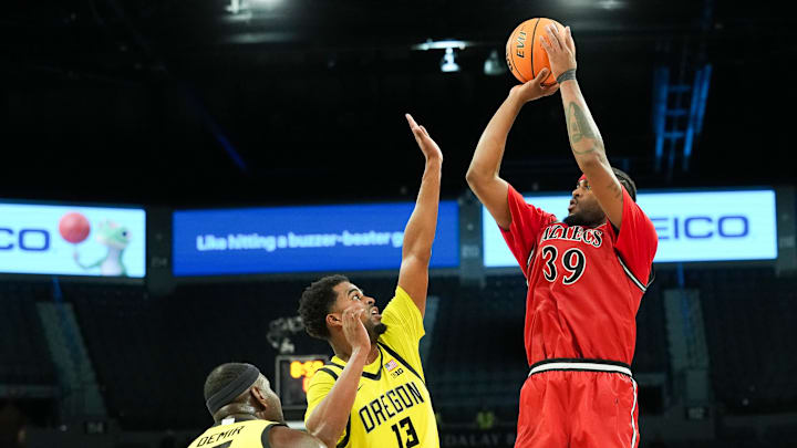 Nov 25, 2025; Las Vegas, Nevada, USA; San Diego State Aztecs guard Reese Dixon-Waters (39) shoots while defended by Oregon Ducks forward Sean Stewart (13) in the second half in a 2025 Players Era Festival group play game at Michelob Ultra Arena.