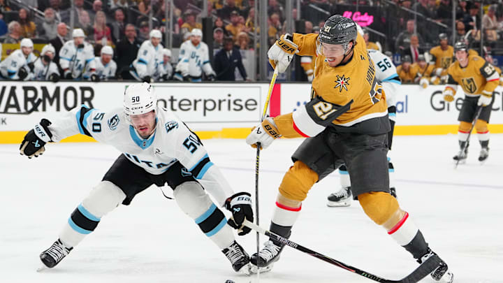 Brett Howden and Sean Durzi battle for the puck