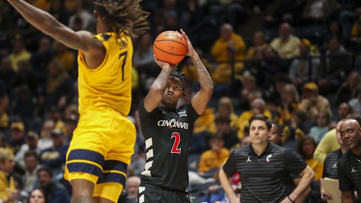 Feb 19, 2025; Morgantown, West Virginia, USA; Cincinnati Bearcats guard Jizzle James (2) shoots a three pointer over West Virginia Mountaineers guard Javon Small (7) during the second half at WVU Coliseum. Mandatory Credit: Ben Queen-Imagn Images