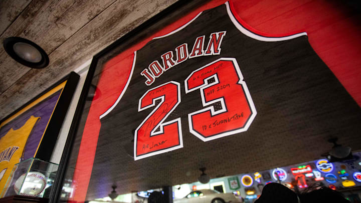 A signed Michael Jordan jersey hangs along with a collection of sports memorabilia. A signed Michael Jordan jersey hangs along with a collection of sports memorabilia.