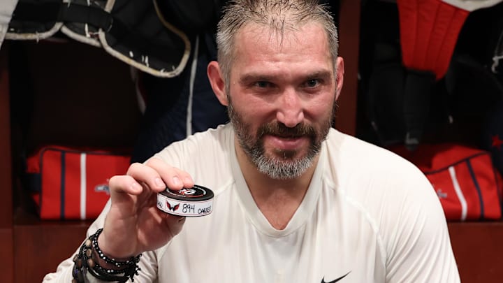 Washington Capitals left wing Alex Ovechkin (8) holds up the puck representing his 894th career goal in the locker room after the game against the Chicago Blackhawks at Capital One Arena. Washington Capitals left wing Alex Ovechkin (8) holds up the puck representing his 894th career goal in the locker room after the game against the Chicago Blackhawks at Capital One Arena.