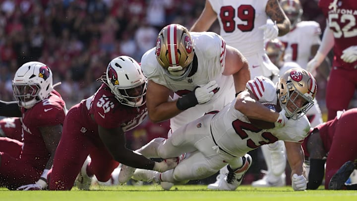 Sep 21, 2025; Santa Clara, California, USA; San Francisco 49ers running back Christian McCaffrey (23) carries the ball as he is tackled by. Arizona Cardinals defensive lineman Darius Robinson (56) during the second half at Levi's Stadium. Mandatory Credit: Kyle Terada-Imagn Images
