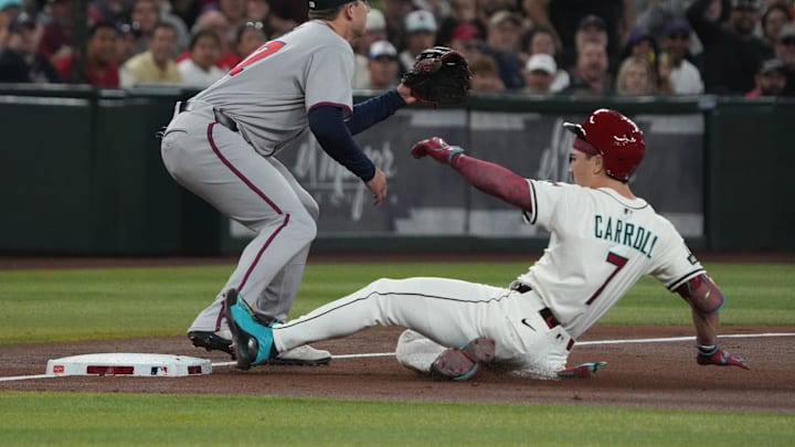 Apr 27, 2025; Phoenix, Arizona, USA; Arizona Diamondbacks outfielder Corbin Carroll (7) slides into thirdbase after hitting a triple in front of Atlanta Braves third base Austin Riley (27) in the first inning at Chase Field. Mandatory Credit: Rick Scuteri-Imagn Images