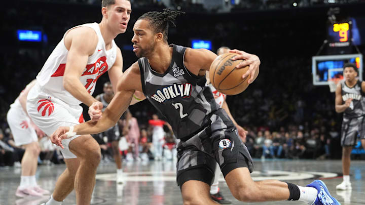 Apr 6, 2025; Brooklyn, New York, USA; Brooklyn Nets forward Tosan Evbuomwan (12) dribbles the ball against Toronto Raptors forward Cole Swider (12) during the second half at Barclays Center. Mandatory Credit: Gregory Fisher-Imagn Images