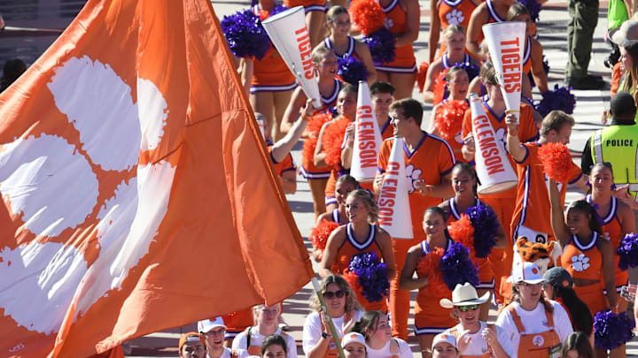 Nov 18, 2023; Clemson, South Carolina, USA;  Clemson cheerleaders, and team walk by fans 