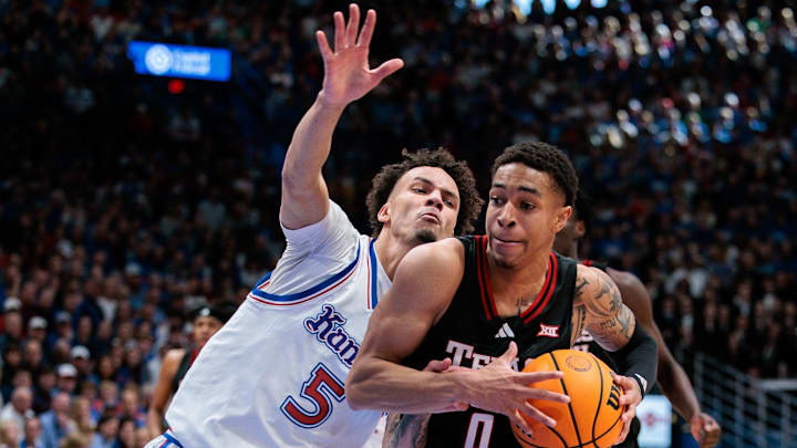 Mar 1, 2025; Lawrence, Kansas, USA; Texas Tech Red Raiders guard Chance McMillian (0) drives to the basket around Kansas Jayhawks guard Zeke Mayo (5) during the first half at Allen Fieldhouse.