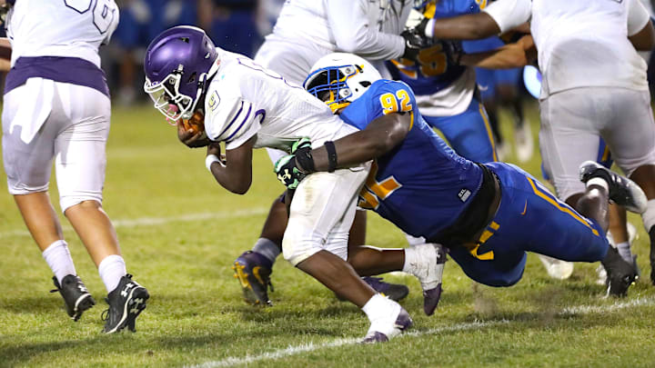 Gainesville High School Joh Cooper (9) is tackled by Newberry High School's Jarquez Carter (92) as