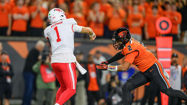 Sep 26, 2025; Corvallis, Oregon, USA; Houston Cougars quarterback Conner Weigman (1) throws a pass under pressure from Oregon State Beavers linebacker Aiden Sullivan (2) during the first quarter at Reser Stadium. Mandatory Credit: Craig Strobeck-Imagn Images
