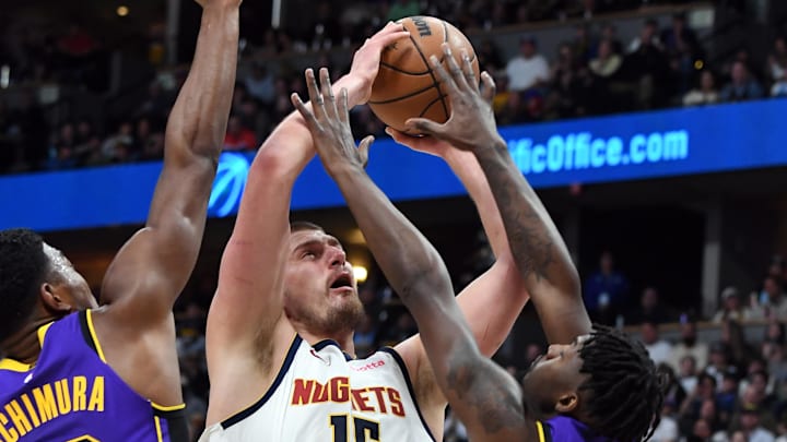 Feb 22, 2025; Denver, Colorado, USA: Denver Nuggets center Nikola Jokic (15) attempts a shot in the lane against Los Angeles Lakers forward Dorian Finney-Smith (17) during the first half at Ball Arena. Mandatory Credit: Christopher Hanewinckel-Imagn Images