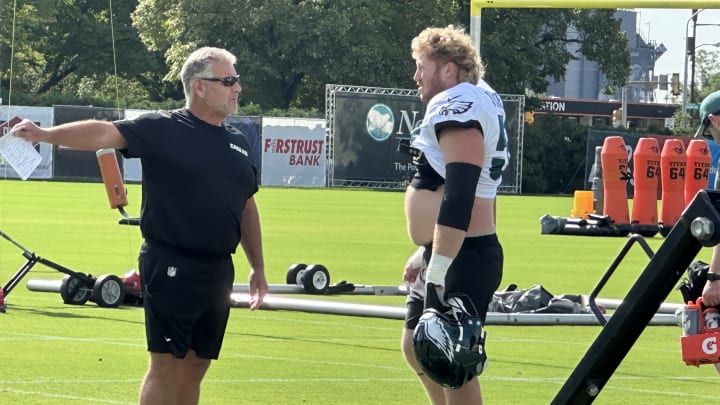 Offensive line coach Jeff Stoutland (left) gives center Cam Jurgens direction during a drill at Eagles training camp. Offensive line coach Jeff Stoutland (left) gives center Cam Jurgens direction during a drill at Eagles training camp.