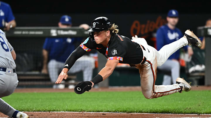 Baltimore Orioles second baseman Jackson Holliday dives into home plate on a passed ball during the fifth inning against the Los Angeles Dodgers at Oriole Park at Camden Yards.