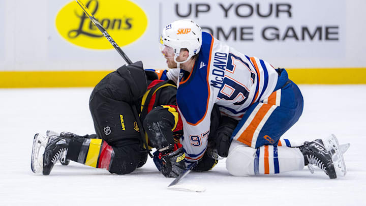 Jan 18, 2025; Vancouver, British Columbia, CAN; Edmonton Oilers forward Connor McDavid (97) battles with Vancouver Canucks forward Conor Garland (8) in the third period at Rogers Arena. Mandatory Credit: Bob Frid-Imagn Images