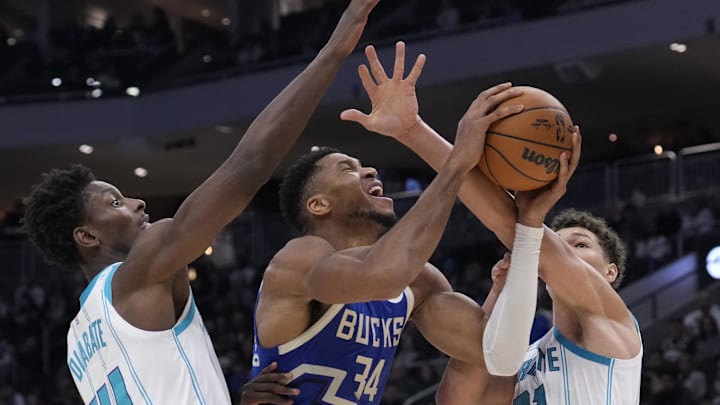 Nov 23, 2024; Milwaukee, Wisconsin, USA; Milwaukee Bucks forward Giannis Antetokounmpo (34) puts up a shot against Charlotte Hornets forward Moussa Diabate (14) and Charlotte Hornets forward Tidjane Salaun (31) in the first half at Fiserv Forum. Mandatory Credit: Michael McLoone-Imagn Images