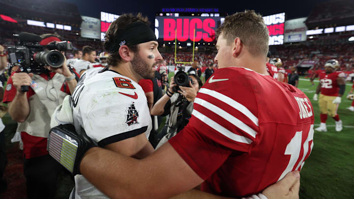 Tampa Bay Buccaneers quarterback Baker Mayfield (6) and San Francisco 49ers quarterback Mac Jones (10) hug.