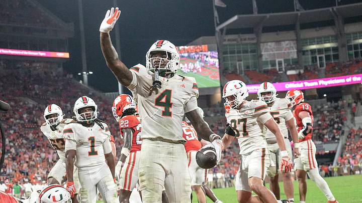 Miami Hurricanes running back Mark Fletcher Jr. (4) dives over the top of Clemson players for a touchdown and lands on his feet and waves to fans during the fourth quarter at Memorial Stadium Saturday, October 3, 2026.